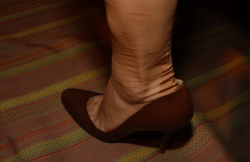Nylonstrümpfe, die Falten schlagen. Ein Fuß in Rupert Sanderson High Heels