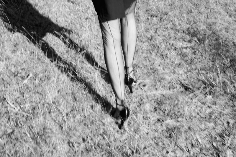 Mit High Heels in der Natur. Zu sehen sind bestrumpften Beine in 15 den Nahtstrümpfen. Zu sehen ist die Hochferse der echten Nahtnylons und die Highheels