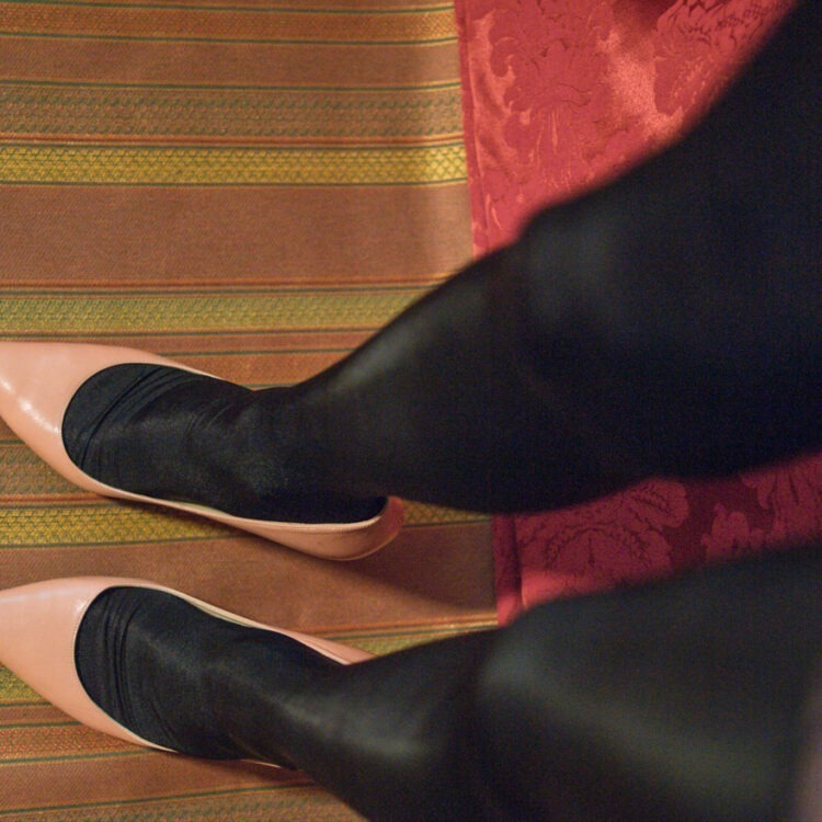 Schwarze Satinstrümpfe in Kombination mit hellen Jimmy Choo Pumps