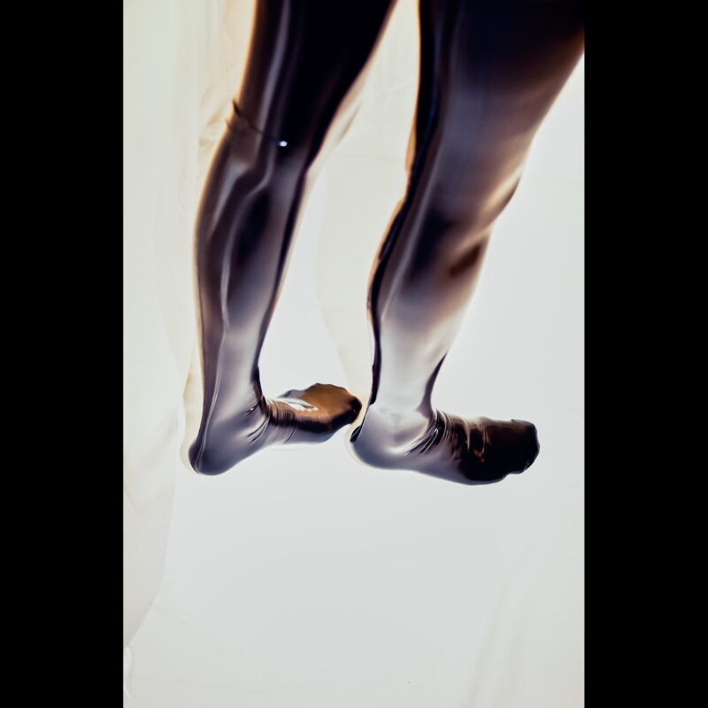 Womens legs and feet in black ff seamed latex stockings with real seam.
