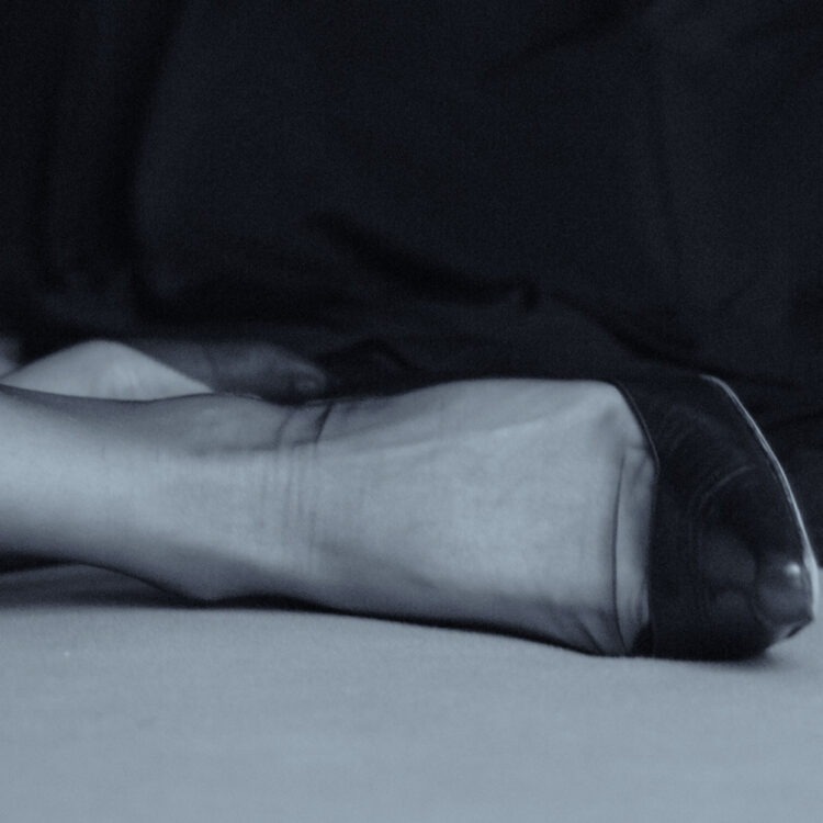 Füße in High Heels. Die Füße liegen auf einer Unterlage