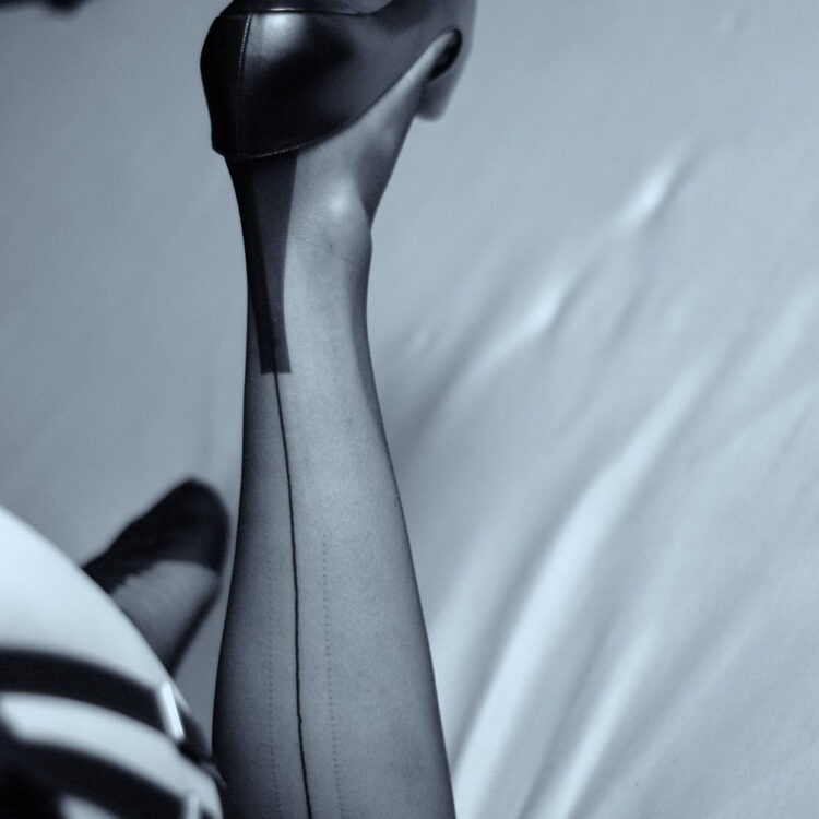 Schwarz-Weiß Foto eines Beins in echten Nahtnylons und Louboutin High Heels