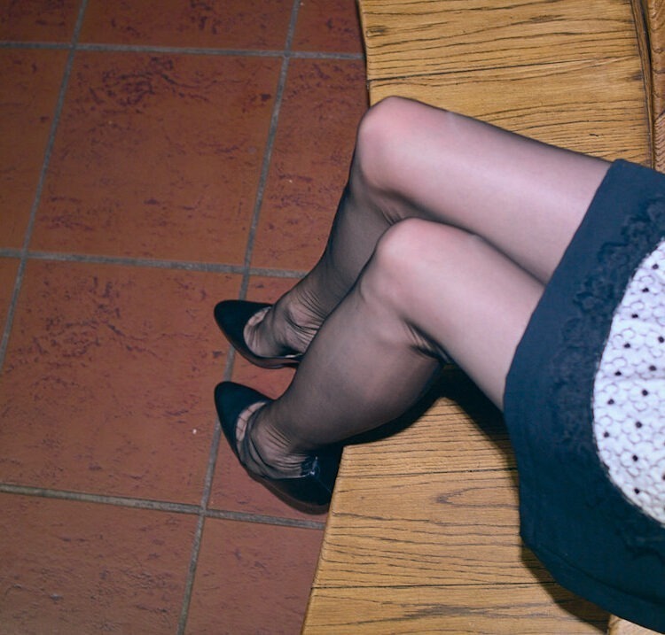 Nahtstrümpfe mit Cuban Heels an den Beinen einer French Maid