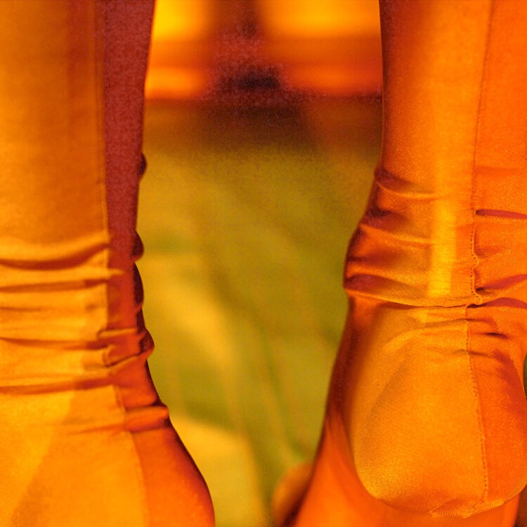 Ich trage echte 60 den Nahtnylons, die sich an meinen Fesseln in Falten werfen.