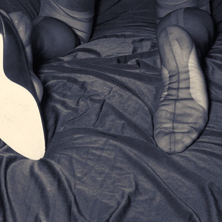 Bestrumpfte Beine in echten Nahtstrümpfen. Ein Fuß mit einer typischen Sohlenverstärkung echter Nahtnylons