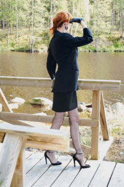 På landet Modell mit schlanken Beinen in echten Nahtstrümpfen. Sie trägt dazu schwarze Jimmy Choo High Heels